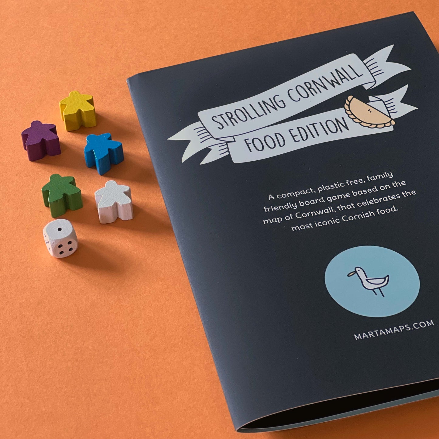 Strolling Cornwall Food Edition with wooden dice and markers. Illustration of a seagull and Cornish pasty.