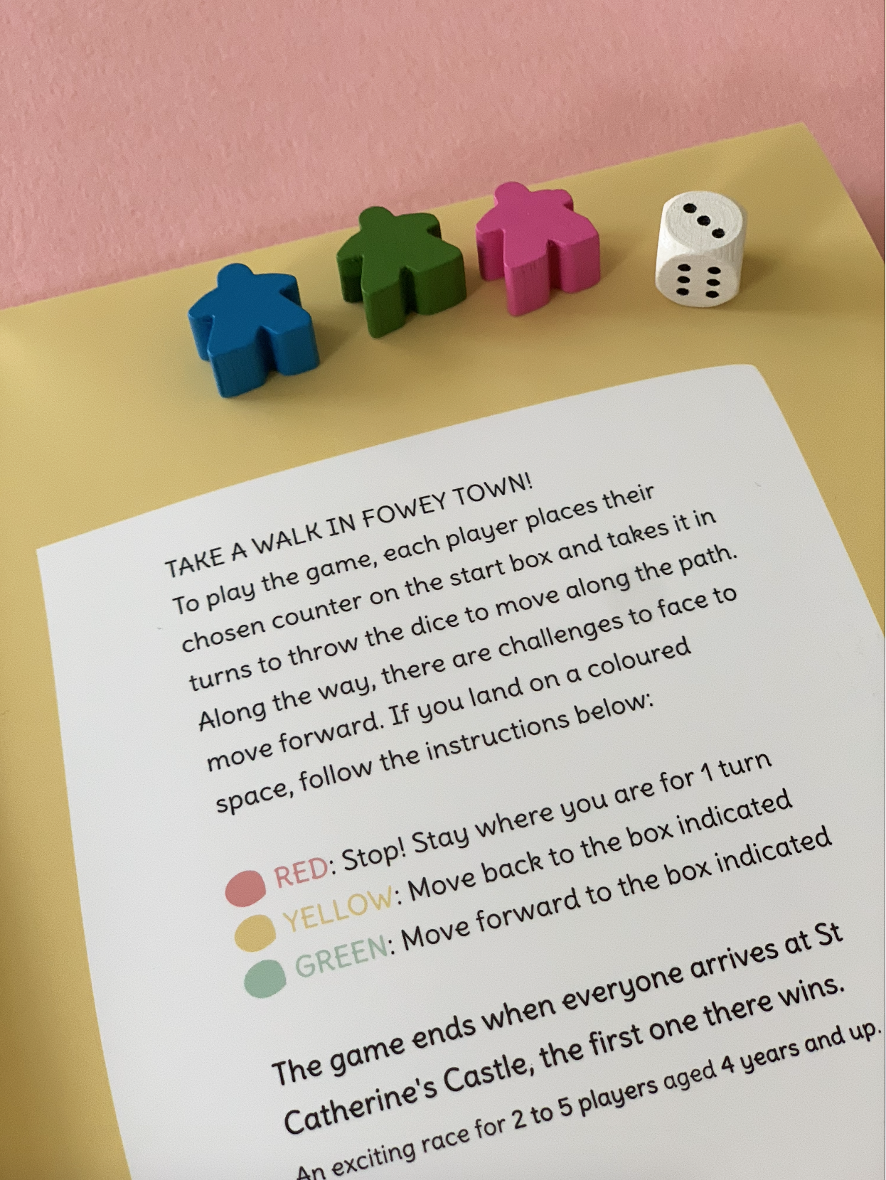 Fowey board game map instructions with wooden dice and coloured markers.