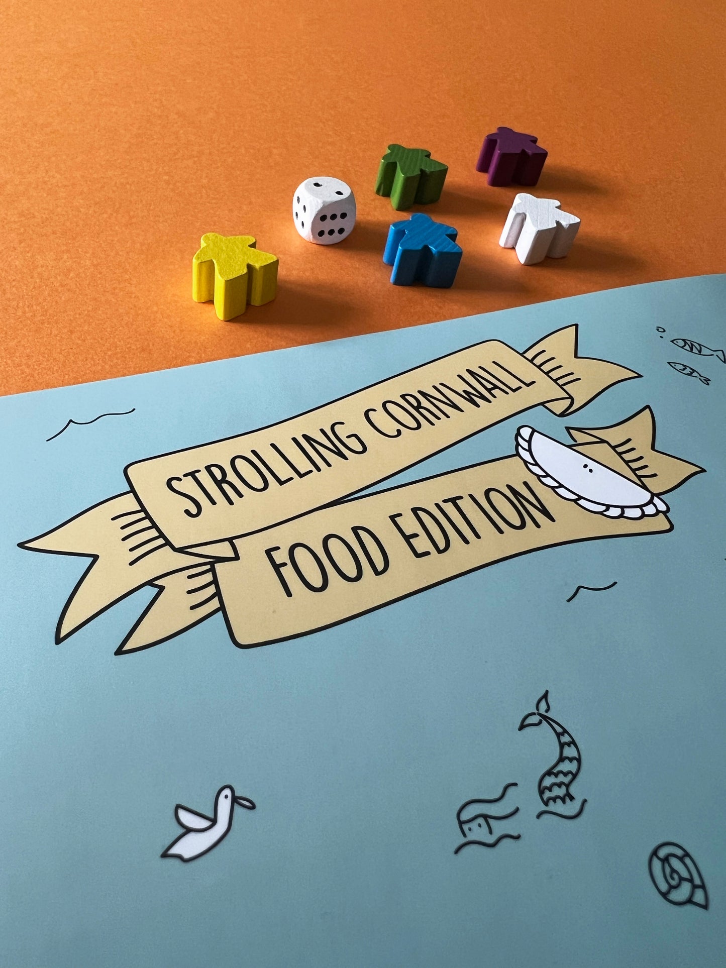 Strolling Cornwall Food Edition with wooden dice and markers. Illustration of a Cornish pasty.