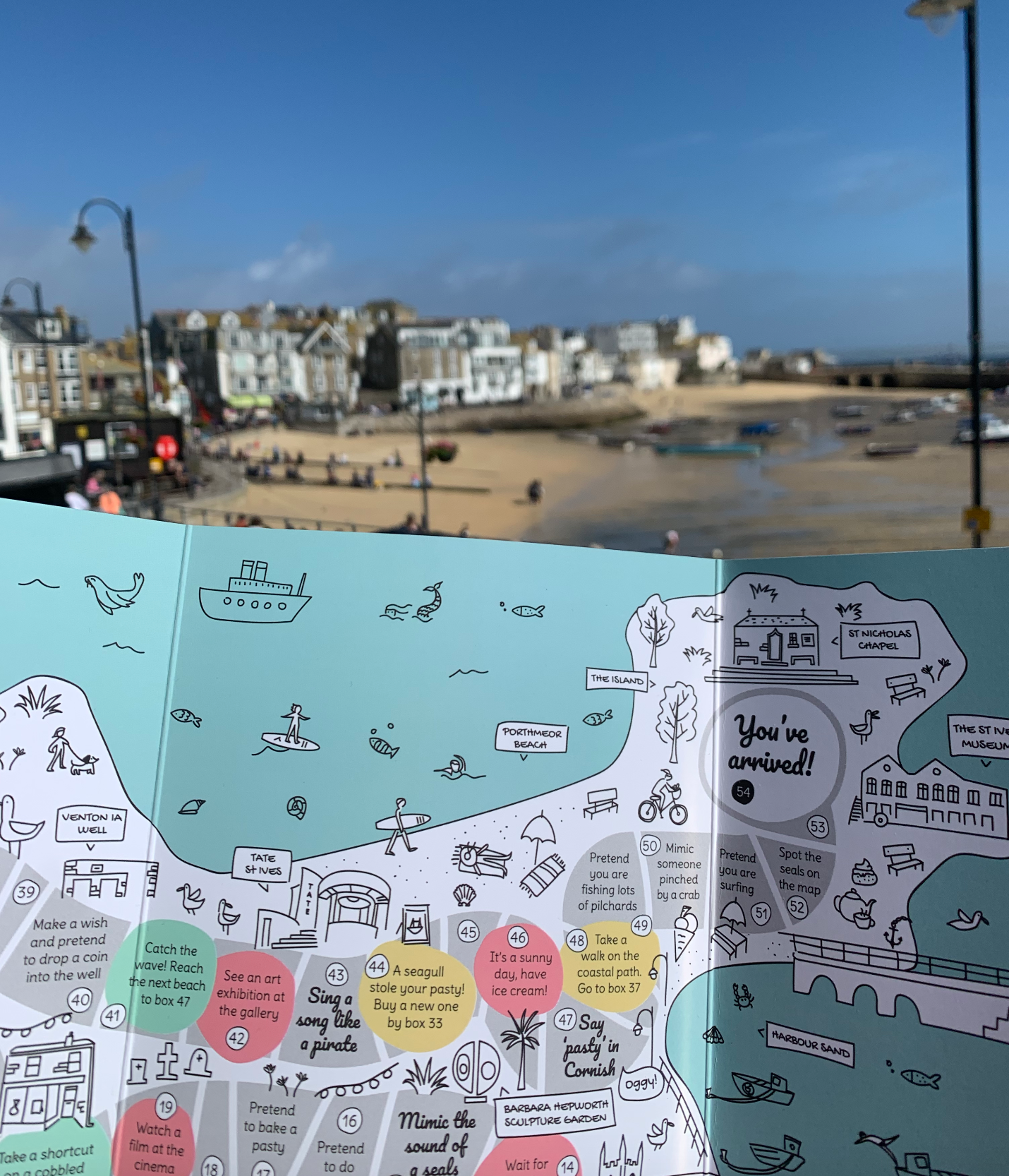 Cornish board game based on the map of St Ives with St Ives bay and town in the background.